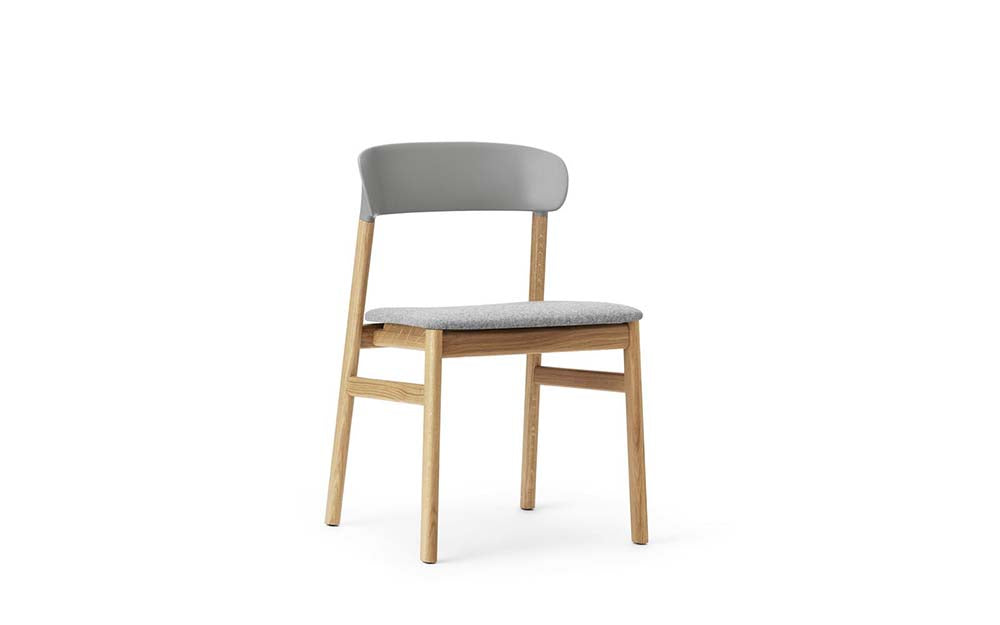 Moderne grijze stoel met eiken poten en polypropyleen rugleuning.