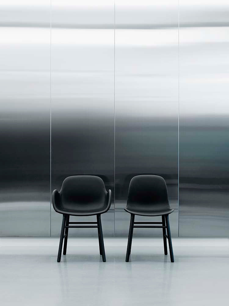 Zwarte plastic stoel met zwarte gelakte houten poten, modern design, geschikt voor eetkamer of kantoor.