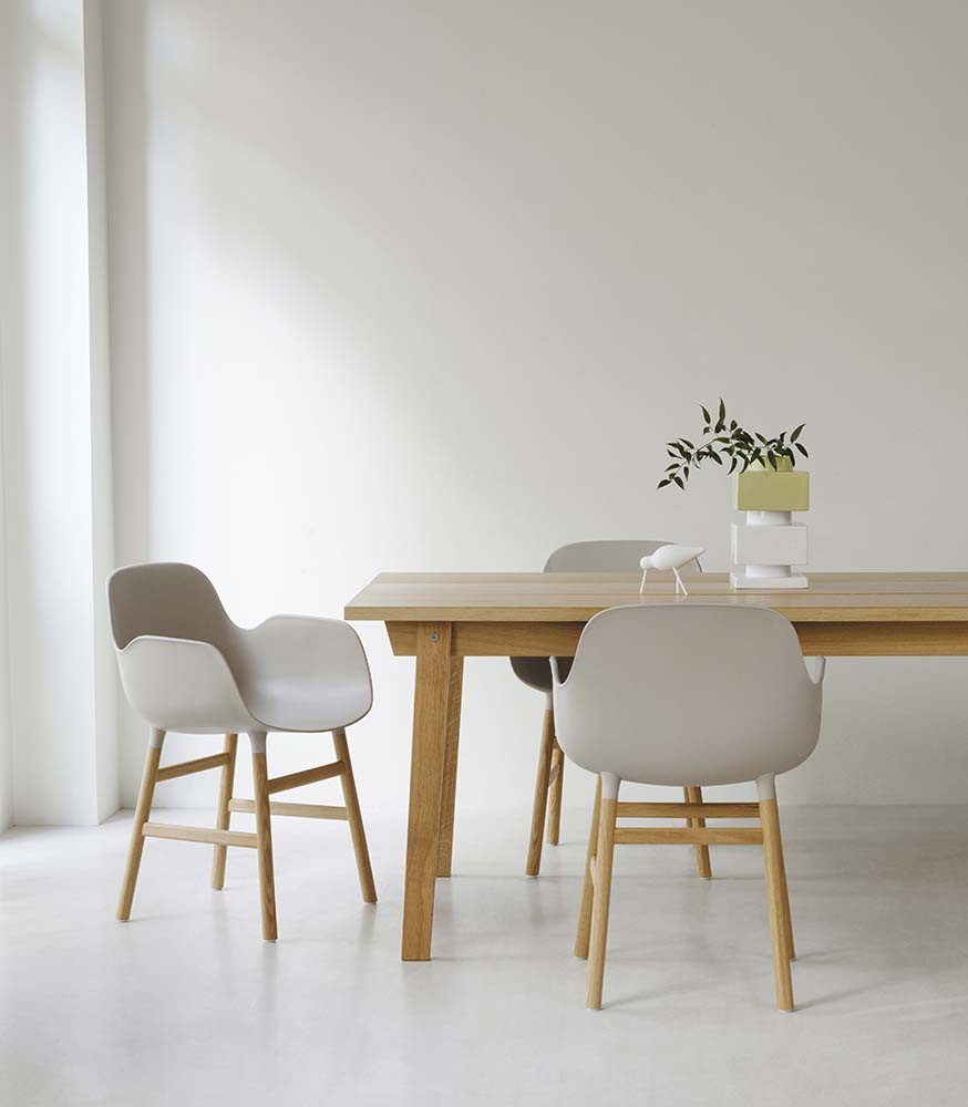 Groene plastic stoel met eikenhouten poten, modern design, geschikt voor woon- en eetkamers.