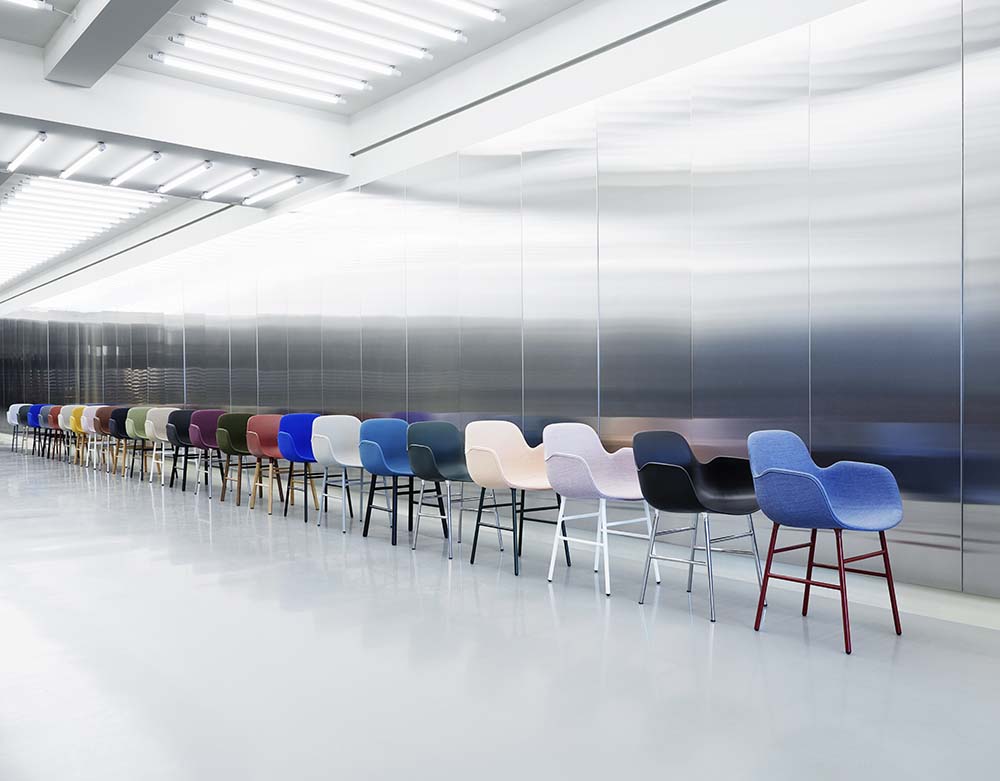 Grijze plastic stoel met gelakte stalen poten, modern design, geschikt voor eetkamer of kantoor. Normann Copenhagen.