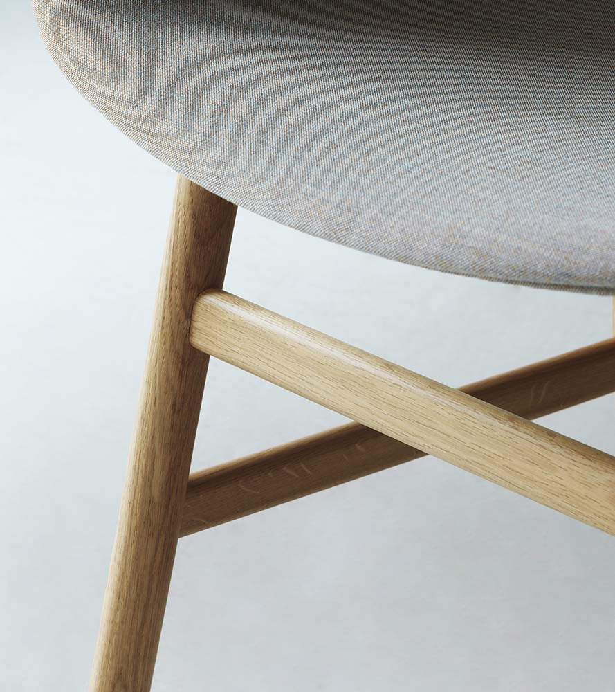 Zwarte plastic stoel met eikenhouten poten, modern design, perfect voor eetkamer of kantoor.